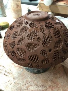 a brown vase sitting on top of a table next to other items in the background