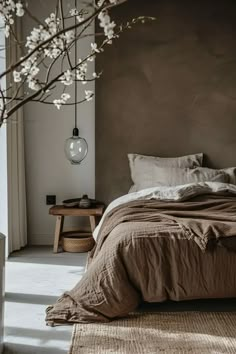 a bed sitting in a bedroom next to a vase with flowers on top of it