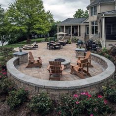 a fire pit surrounded by lawn chairs and flowers