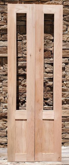 two wooden doors sitting next to each other on top of a stone wall and floor