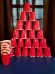 a stack of red cups sitting on top of a blue table