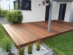 a wooden deck in front of a white house