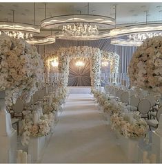 the aisle is decorated with white flowers and candles