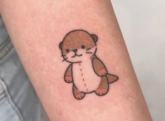 a small otter tattoo on the arm