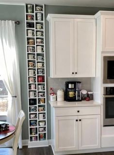 a kitchen with white cabinets and gray walls