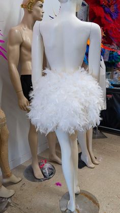 two mannequins dressed in white feathers on display