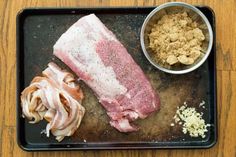 raw meat and other ingredients on a black tray