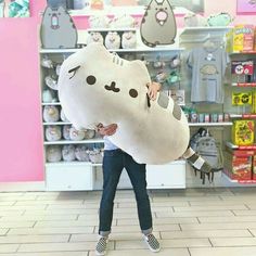 a woman carrying a large stuffed animal in a store