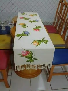 a table with a white table cloth on it next to two chairs and a vase