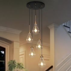 a chandelier with five light bulbs hanging from it's ceiling in a house