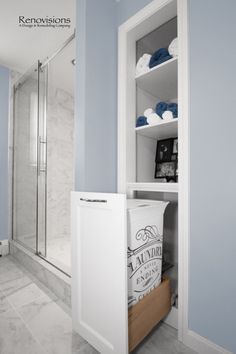 a bathroom with blue walls and white cabinetry in the corner, along with a walk - in shower