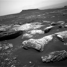 some rocks are in the water and one is covered with snow