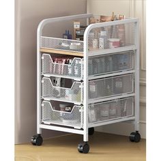 a white cart with four drawers on wheels in front of a wall and flooring