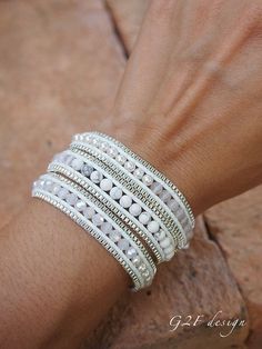 a close up of a person's hand wearing white bracelets