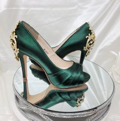 Hunter Green Wedding Shoes with sparkling crystals and gold design on the heel of the shoes. FEATURES: High Heel (3 1/2 inches) Hidden Platform ( 1/2 inch) Satin upper Leather Sole Peep toe Designed in the USA If you would like the shoes dyed a color from my color chart, please leave the dye color you would like in the TEXT BOX. If you would like to send me a swatch to color match please indicate that in the TEXT BOX. I will email you the address to mail the swatch once I receive your order.If y Gold Quinceanera Heels, Glamorous Rhinestone Wedding Shoes For Reception, Gold Pointed Toe Shoe Clips For Wedding, Gold Heels With Rhinestones For Wedding, Gold Rhinestone Heels For Wedding, Gold Crystal-embellished Wedding Shoes For Gala, Gold Embellished Wedding Shoes For Gala, Gold Rhinestone Wedding Heels, Glamorous Round Toe Wedding Shoes For Reception