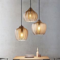 three lights hanging over a table in a room