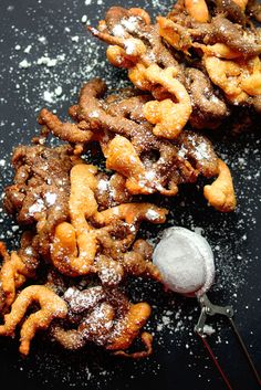 some food is laying out on a table with utensils and powdered sugar