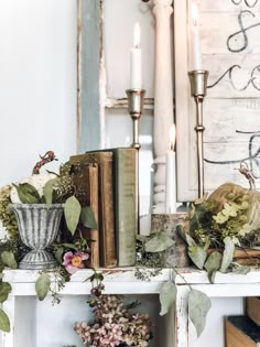 a mantle with books, flowers and candles on it