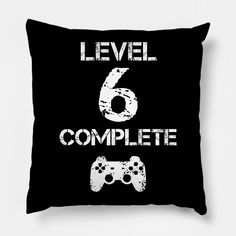 a black pillow with the words level 6 complete and two video game controllers on it