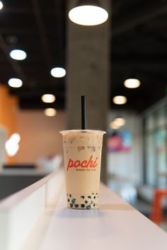 a cup with a black straw sitting on top of a counter