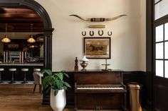 a living room filled with furniture and a piano in front of a window next to a potted plant