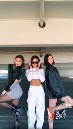 three women posing for the camera in front of a sign that says, outfitting jeans