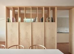 a table with chairs and bookshelves in a room