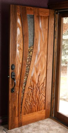 the front door is made out of wood and has an intricate carving pattern on it