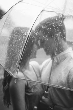 a couple kissing under an umbrella in the rain