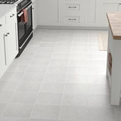 a kitchen with white cabinets and tile flooring