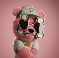 a pink teddy bear with sunglasses and money on his chest, wearing a hat and heart shaped glasses