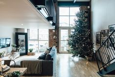 a living room filled with furniture and a christmas tree in the middle of the room