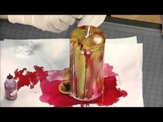 someone is painting an apple with red liquid