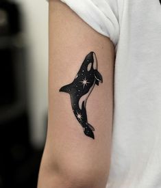 a black and white orca whale tattoo on the arm