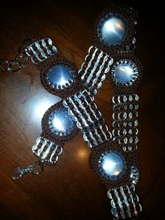 three pieces of jewelry sitting on top of a wooden table