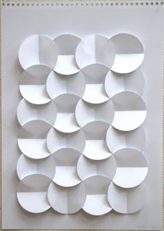 a white paper sculpture with circles on the bottom and one circle in the middle that has been cut out