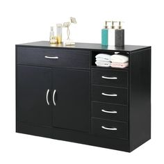 a black cabinet with drawers and towels on it's sides, in front of a white background