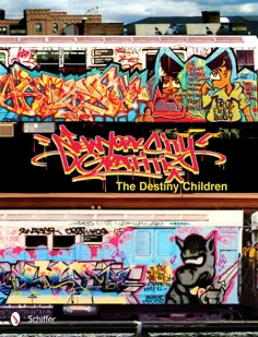 two train cars covered in graffiti sitting next to each other