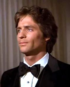 a man in a tuxedo looks off into the distance