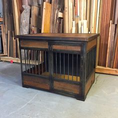 a dog crate sitting on the floor in front of some wood planks and other items