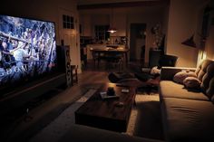 a living room filled with furniture and a flat screen tv sitting on top of a wooden table