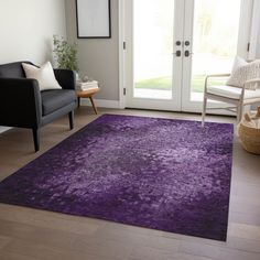 a living room with a purple rug on the floor next to a chair and door