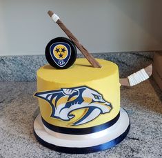 a cake with a hockey puck on top and a nashville predators logo on the side