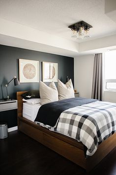 a bedroom with black walls and white bedding