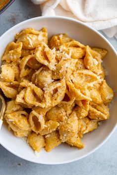 a white bowl filled with macaroni and cheese on top of a blue table