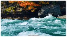 the water is very choppy and blue with white foamy waves in front of some rocks