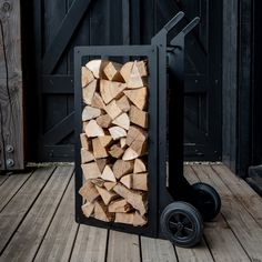 a pile of wood sitting on top of a wooden floor next to a black cart