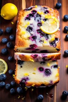 two slices of lemon blueberry bread on a cutting board with sliced lemons and blueberries