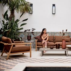 a woman sitting on top of a couch next to a table