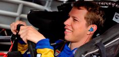 a young man wearing ear buds sitting in a car